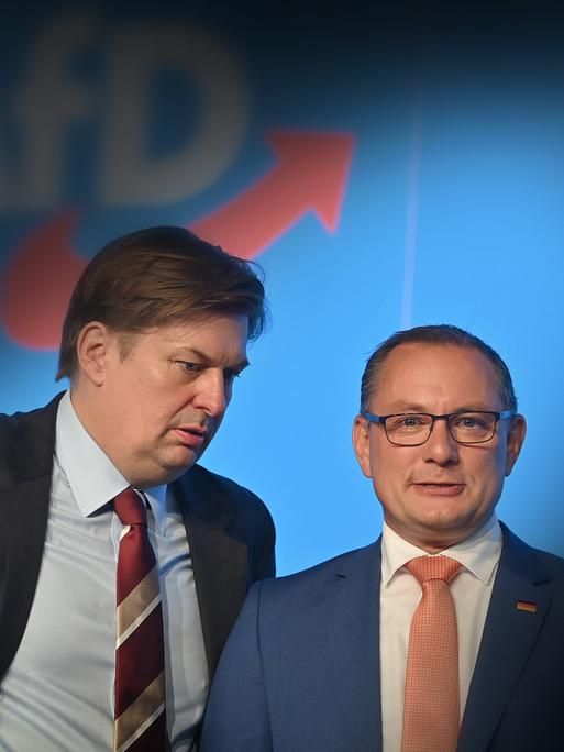 Tino Chrupalla schaut in die Kamera, Krah schaut zu Chrupalla