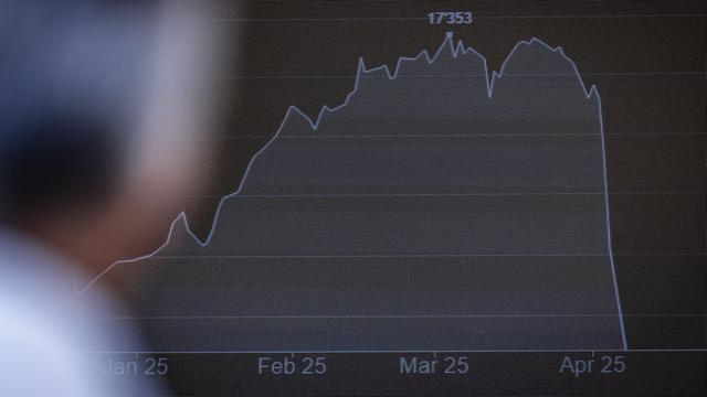 Ein Mann betrachtet an einer LED-Wand in der Neuen Börse Zürich-West die abgestürzte Kurve der  Börsenkurse.