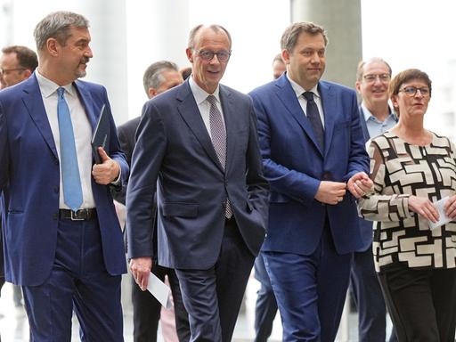 Von links nach rechts sind CSU-Vorsitzender Markus Söder, Unions-Kanzlerkandidat Friedrich Merz, SPD-Fraktions- und Bundesvorsitzender Lars Klingbeil und SPD-Bundesvorsitzende Saskia Esken zu sehen. Sie gehen gemeinsam zu einer Pressekonferenz.
