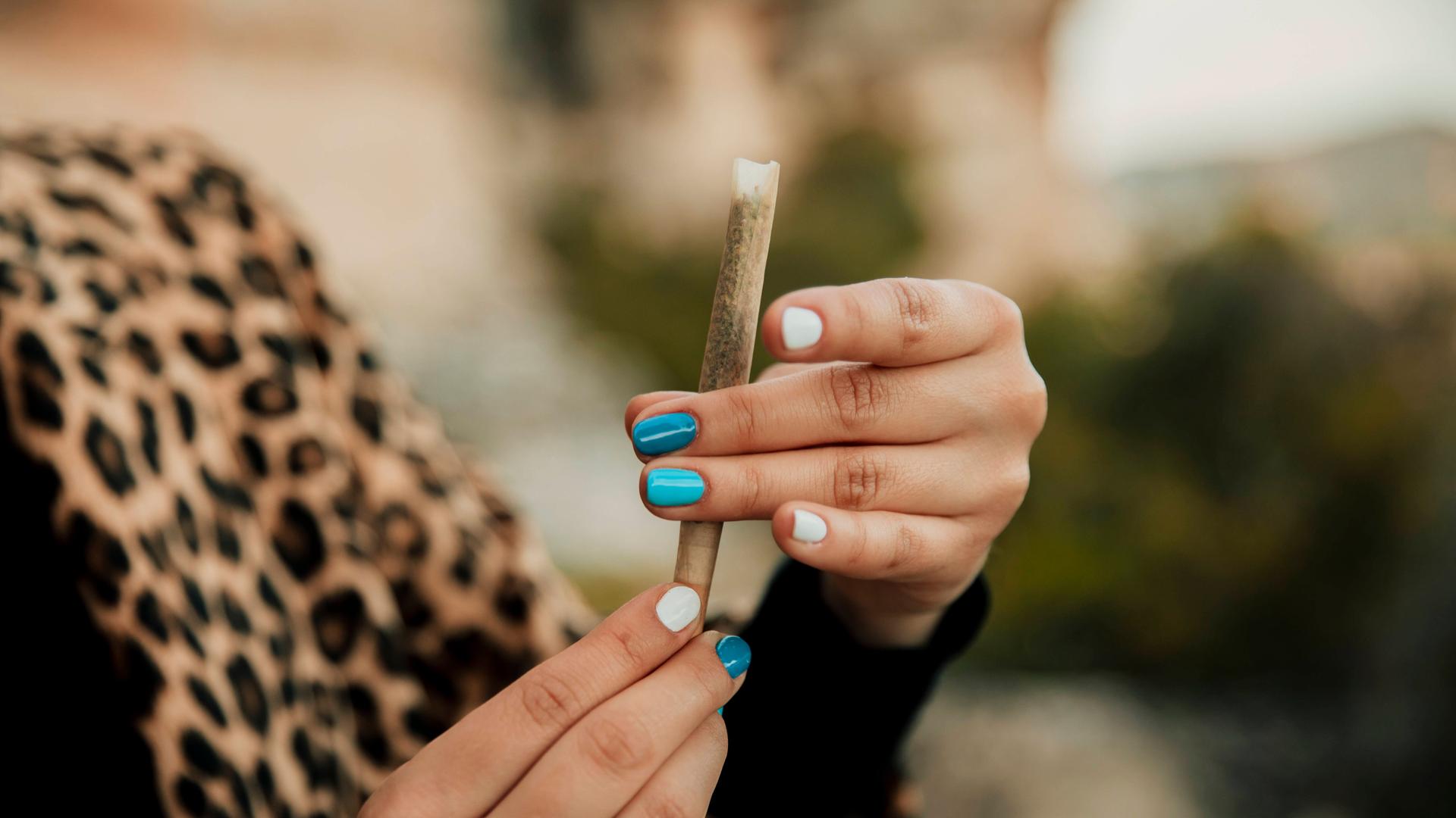 Eine junge Frau dreht sich einen Joint.