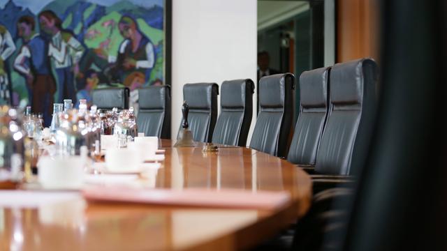 Der ovale Tisch im Sitzungssaal des Bundeskabinetts ist mit Getränken gedeckt, Akten liegen bereit.