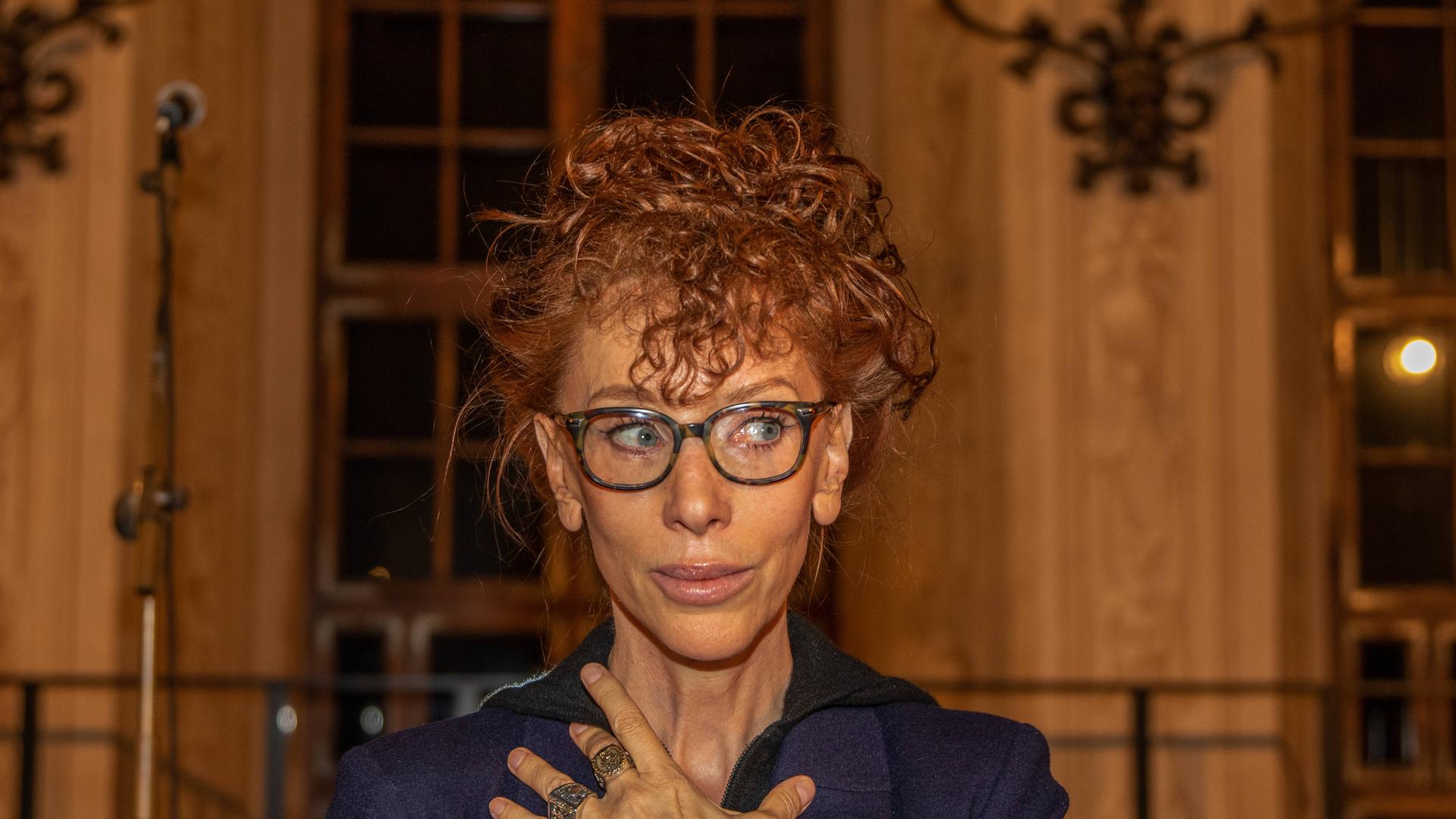 Sibylle Berg auf der Bühne bei der Auszeichnung Bertold-Brecht-Preis in Augsburg. Sibylle Berg hat einen Dutt, eine Brille und schaut nach rechts. 