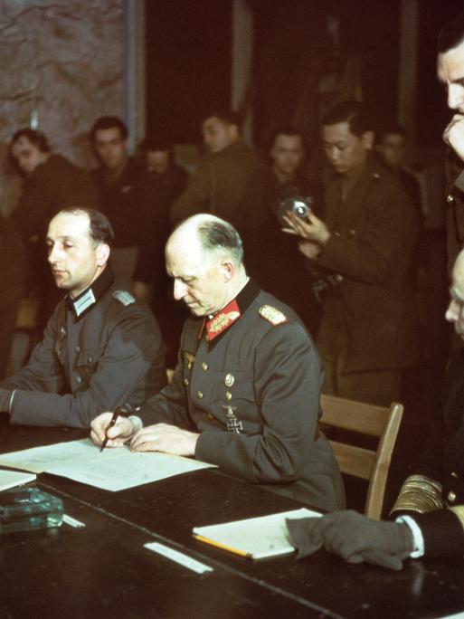 Im Alliierten Hauptquartier in Reims wurde um 2.41 Uhr am 07.05.1945 die Kapitulationsurkunde von Generaloberst Alfred Jodl (M) im Namen der Deutschen Wehrmacht unterzeichnet. 