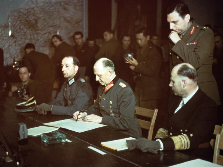 Im Alliierten Hauptquartier in Reims wurde um 2.41 Uhr am 07.05.1945 die Kapitulationsurkunde von Generaloberst Alfred Jodl (M) im Namen der Deutschen Wehrmacht unterzeichnet. 