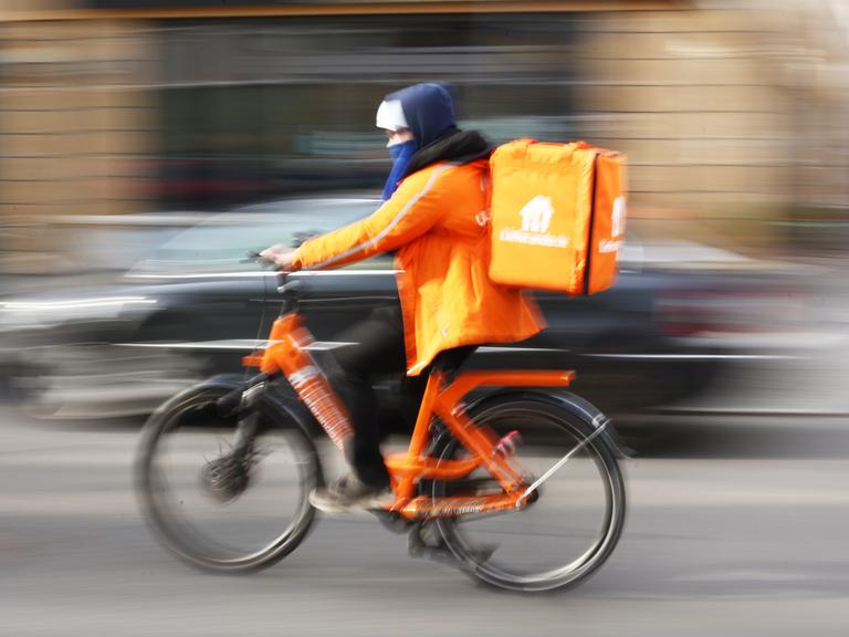 Ein Fahrer von Lieferando fährt auf seinem Rad in Berlin im Bezirk Mitte auf der Friedrichstraße