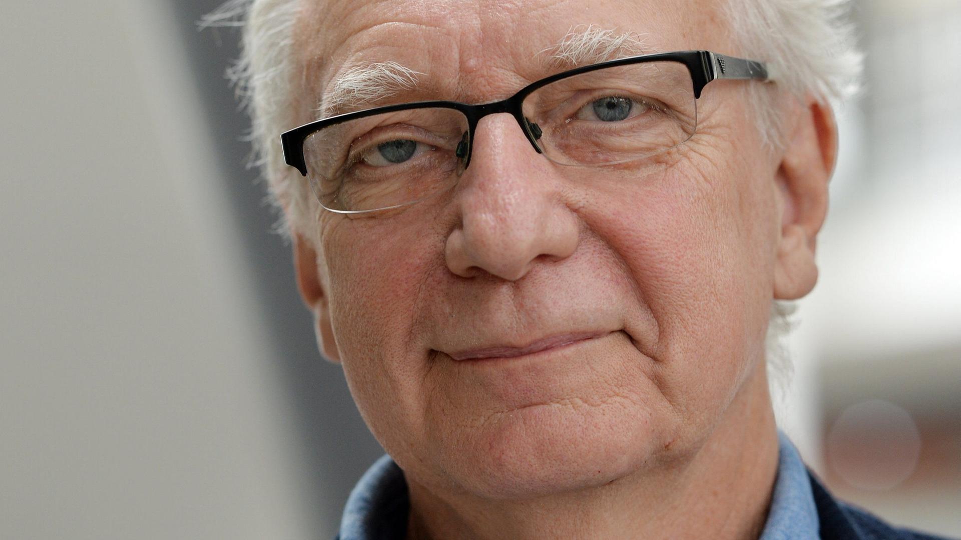 Claus Leggewie trägt ein hellblaues Hemd und ein dunkelblaues Sakko
