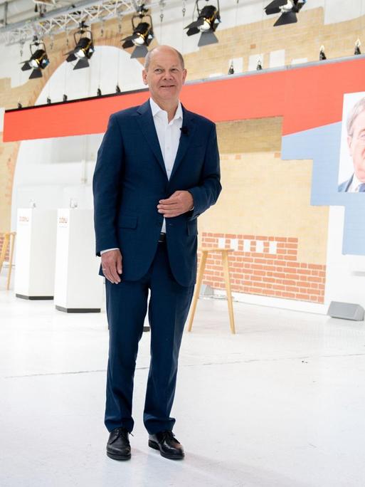 Annalena Baerbock (l), Kanzlerkandidatin und Bundesvorsitzende von Bündnis 90/Die Grünen, Olaf Scholz, SPD-Kanzlerkandidat und Bundesminister der Finanzen, und Christian Lindner, FDP-Spitzenkandidat, Fraktionsvorsitzender und Parteivorsitzender der FDP, stehen zu Beginn einer Gesprächsrunde zusammen in einem Studio. Im Hintergrund ist eine Digitalbild von Armin Laschet (CDU), CDU-Kanzlerkandidat und Ministerpräsident von Nordrhein-Westfalen, zu sehen.