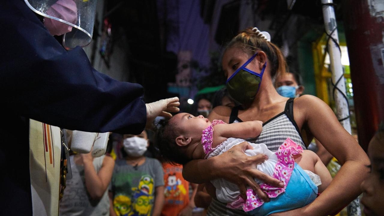 Pater Eduardo Pon Vasquez bei der Salbung eines Kindes mit Weihwasser zur Taufe auf den katholischen Glauben am 30. April 2020 in Caloocan, Philippinen. Pater Pon ist der Ansicht, dass alle ungetauften Kinder gesalbt und in die katholische Fatih aufgenommen werden sollten, da die Pandemie unter den hilflosen Bewohnern Unsicherheit in das Leben bringt. Mit einem Kreuz und einer heiligen Bibel bewaffnet und mit einem behelfsmäßigen Schutzanzug und Gesichtsschutzschildern bekleidet, besucht Pater Eduardo Pon Vasquez, der seit 17 Jahren römisch-katholischer Priester der Oblaten der Unbefleckten Jungfrau Maria ist, die ärmeren Gemeinden in der Stadt Caloocan, um sicherzustellen, dass während einer von der Regierung verhängten Abriegelung zur Verhinderung der Ausbreitung des Coronavirus Randgruppen und Obdachlose versorgt werden. Zusammen mit Pater Rey Emmanuelle Amancio, 31, versorgen sie die Bedürftigen in ihrer Gemeinde mit Lebensmitteln, Masken und Worten des Trostes. Wenn die Menschen in diesen sehr prekären Zeiten nicht herauskommen können, um in die Kirche zu gehen, sollte die Kirche zu ihnen kommen, sagt Pater Pon. Pater Eduardo Pon Vasquez bei der Salbung eines Kindes mit Weihwasser zur Taufe auf den katholischen Glauben am 30. April 2020 in Caloocan, Philippinen. Pater Pon ist der Ansicht, dass alle ungetauften Kinder gesalbt und in die katholische Fatih aufgenommen werden sollten, da die Pandemie unter den hilflosen Bewohnern Unsicherheit in das Leben bringt. Mit einem Kreuz und einer heiligen Bibel bewaffnet und mit einem behelfsmäßigen Schutzanzug und Gesichtsschutzschildern bekleidet, besucht Pater Eduardo Pon Vasquez, der seit 17 Jahren römisch-katholischer Priester der Oblaten der Unbefleckten Jungfrau Maria ist, die ärmeren Gemeinden in der Stadt Caloocan, um sicherzustellen, dass während einer von der Regierung verhängten Abriegelung zur Verhinderung der Ausbreitung des Coronavirus Randgruppen und Obdachlose versorgt werden. Zusammen mit Pater Rey Emmanuelle Amancio, 31, versorgen sie die Bedürftigen in ihrer Gemeinde mit Lebensmitteln, Masken und Worten des Trostes. Wenn die Menschen in diesen sehr prekären Zeiten nicht herauskommen können, um in die Kirche zu gehen, sollte die Kirche zu ihnen kommen, sagt Pater Pon.