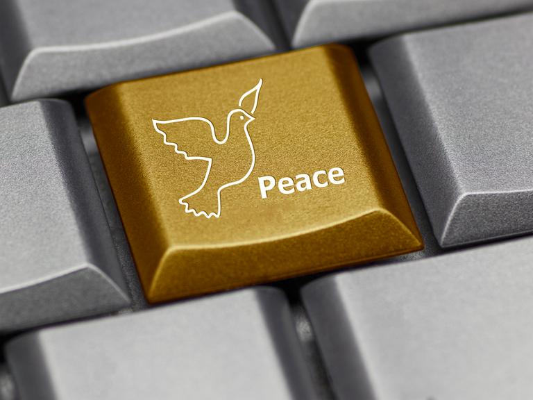 Eine graue Computer-Tastatur mit einer goldenen Friedenstaube darauf