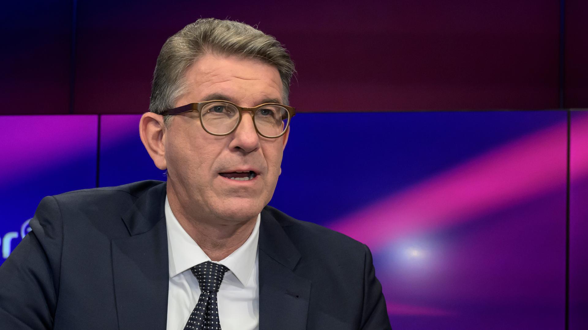 Der Publizist und Verleger Wolfram Weimer schaut mit offenem Mund in die Kamer. Er trägt eine Brille und einen Anzug.