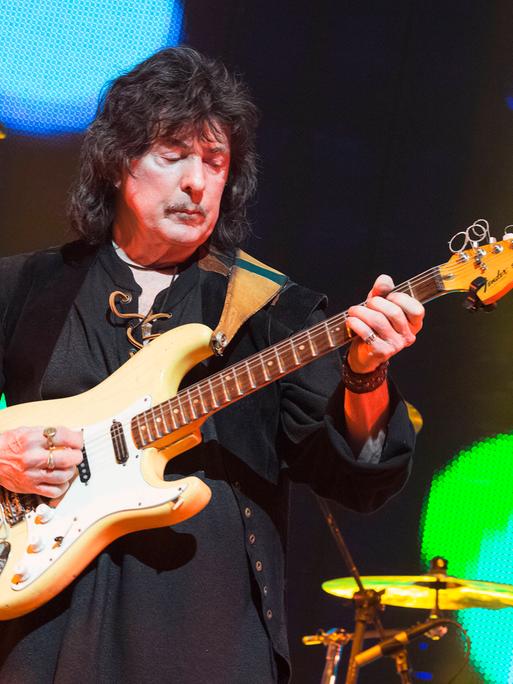 Blick auf den Gitarristen Ritchie Blackmore, der hier bei einem Konzert 2018 auf einer bunt beleuchteten Bühne spielt.