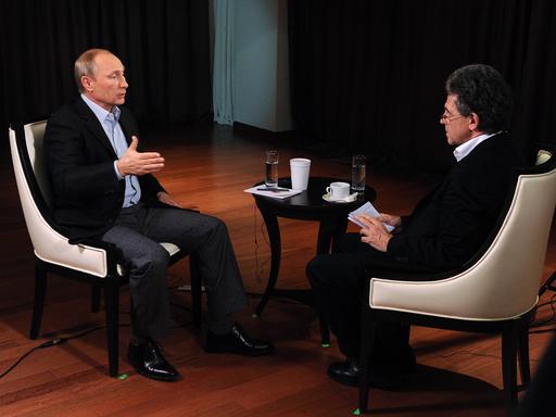 Hubert Seipel und Putin sitzen sich in auf Sesseln gegenüber und unterhalten sich.