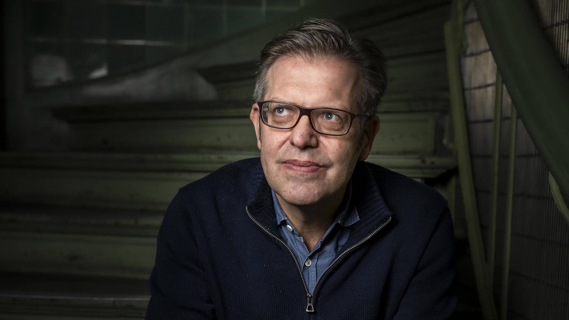 Steffen Mau, Soziologe für Makrosoziologie am Institut für Sozialwissenschaften der Humboldt-Universität zu Berlin, HU sitzt auf einer Treppe.