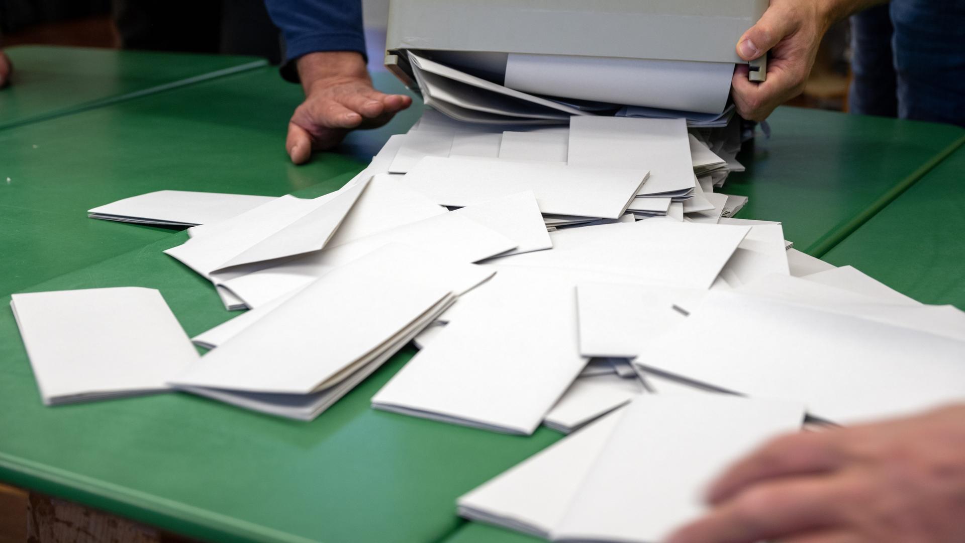 Eine Wahlurne wird ausgeleert, die Auszählung der Stimmzettel beginnt.