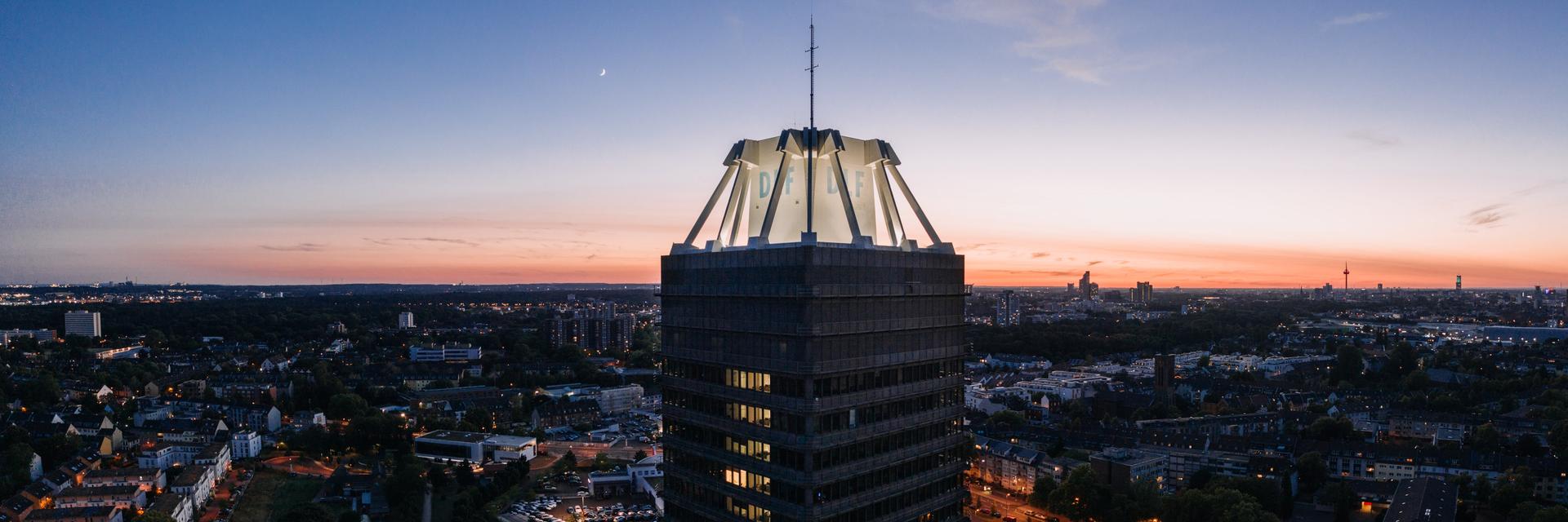 Das Hochhaus des Deutschlandfunks in einer Luftaufnahme bei Abenddämmerung Das Hochhaus des Deutschlandfunks in einer Luftaufnahme bei Abenddämmerung