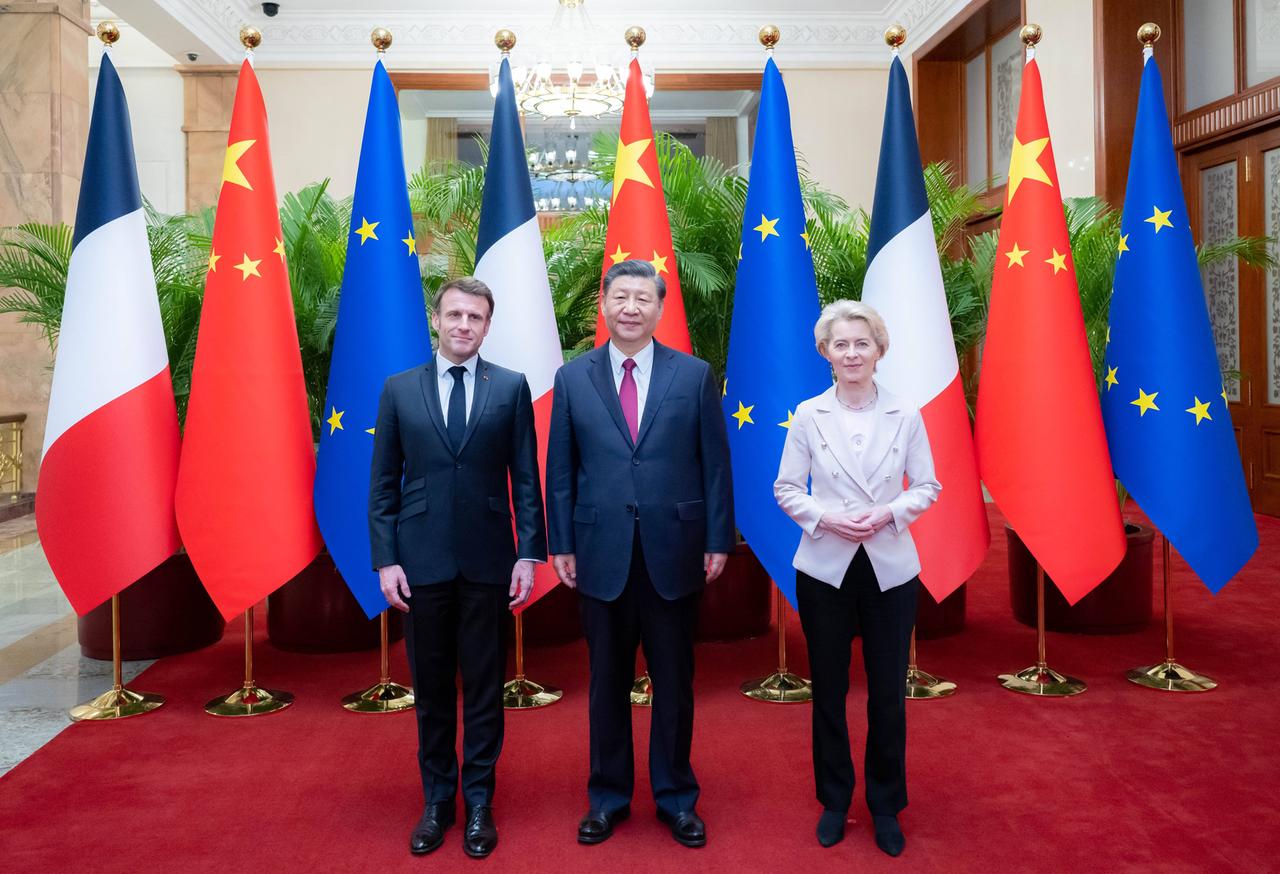 Drei Personen stehen vor der französischen, der chinesischen und der europäischen Flaggen. Drei Personen stehen vor der französischen, der chinesischen und der europäischen Flaggen.