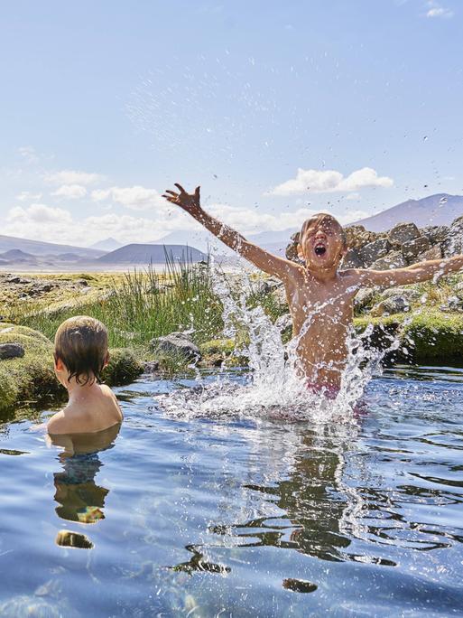 Zwei Jungen beim Baden in einer heißen Quelle in Chile.